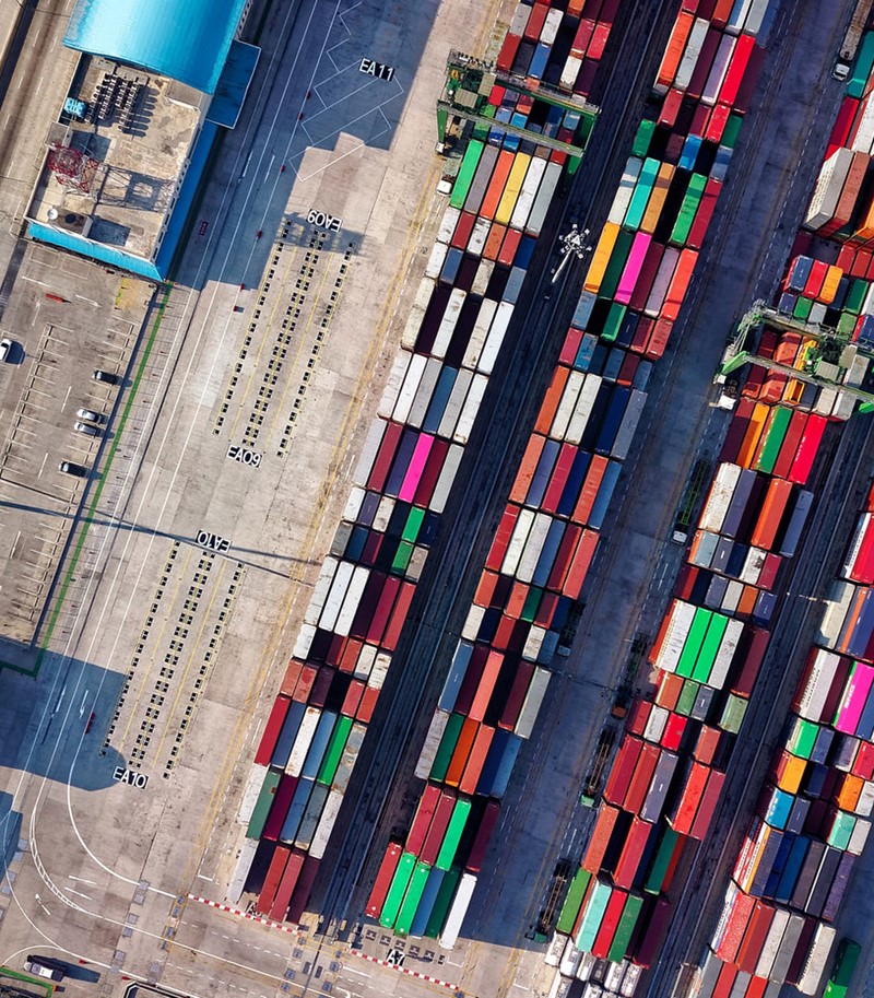 Overhead aerial shot of several stacks of multi-coloured containers stored on a dock