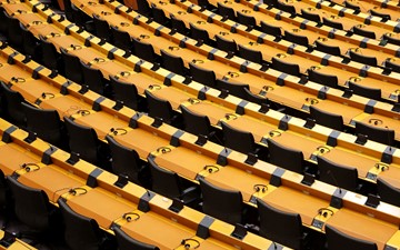 Rows of empty seats from a parliament hemicycle with headphones on desks and electronic voting equipment fitted